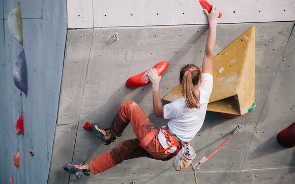Woman is climbing over a overhang at the climbing hall.  | © Shutterstock