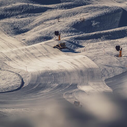 Im goldenen Abendlicht fährt der Pistenbully über die Piste und hinterlässt eine perfekt präparierte Spur. | © Davos Klosters Mountains