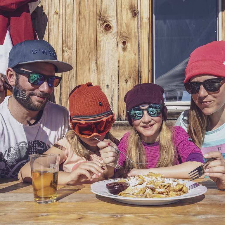 Family shares a Kaiserschmarn in the Hubelhütte. | © Davos Klosters Mountains