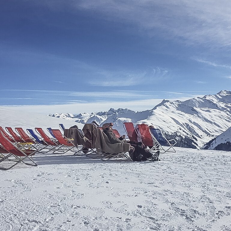 Rote Liegen stehen aufgereiht auf der Aussichtsterrasse der Gruobenalp. | © Davos Klosters Mountains