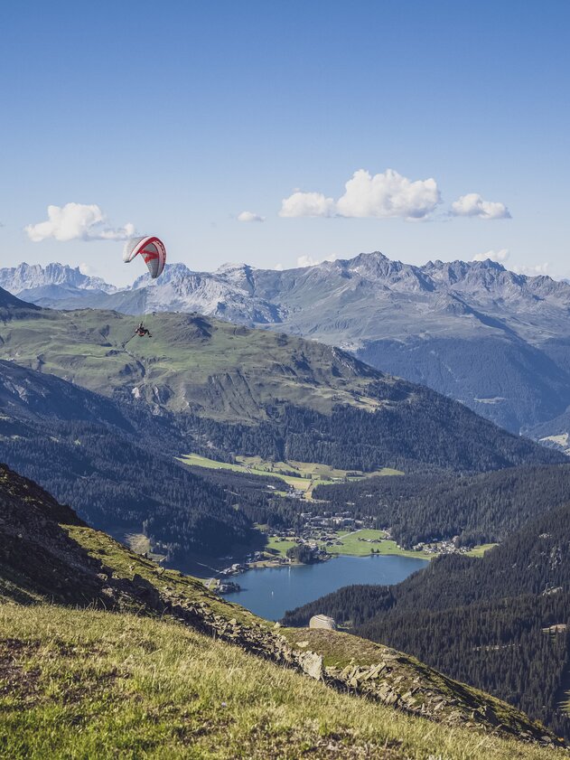 Paragliding flight Davosersee | © Davos Klosters Mountains During the flight from the Brämabüel Jakobshorn into the valley, the paraglider enjoy the view to the mountains and to the Lake Davos. | © Davos Klosters Mountains