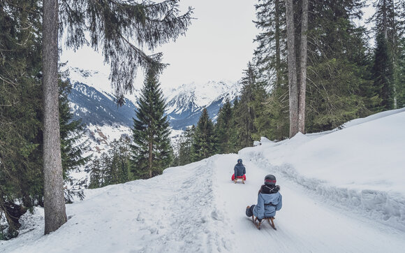 Two friends sledge down the Gotschna toboggan run into the valley to Klosters. | © Davos Klosters Mountains