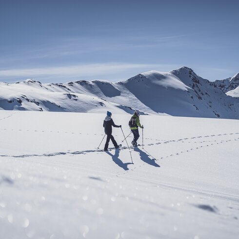 Zwei Frauen laufen mit den Schneeschuhen durch den tiefen Schnee. | © Davos Klosters Mountains