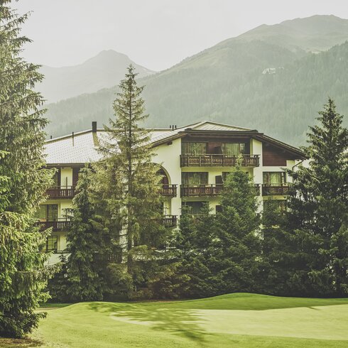Mehrstöckiges Gebäude mit Balkonen umringt von Nadelbäumen  | © Davos Klosters Mountains 