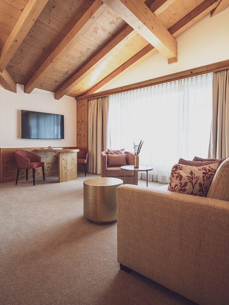 Hotel room with lots of wood and couch | © Davos Klosters Mountains