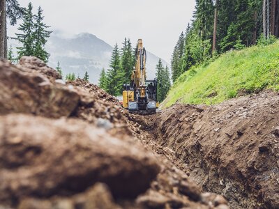 Im Sommer gräbt ein Bagger einen Graben auf der Talabfahrt Jakobshorn. | © Davos Klosters Mountains