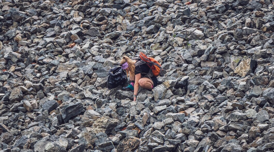 A participant of the environmental camp is looking for waste in a scree field.  | © Davos Klosters Mountains