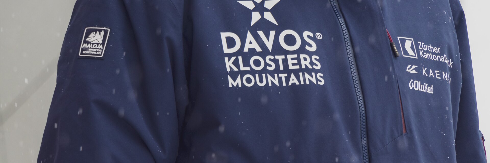 Die rot/blaue Jacke der Marke Maloja  gehört zur neuen Mitarbeiterkleidung der Davos Klosters Mountains.  | © Davos Klosters Mountains