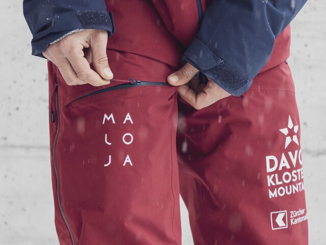Die rote Jacke der Marke Maloja  wird von den Mitarbeitenden der Davos Klosters Mountains getragen.  | © Davos Klosters Mountains
