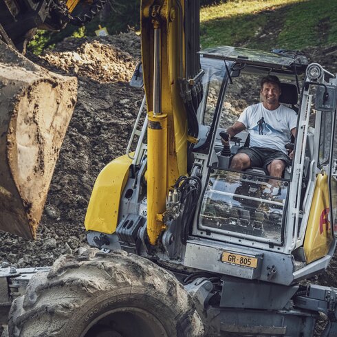 Andreas Grassel arbeitet mit dem gelben Menzi Muck Bagger. | © Davos Klosters Mountains