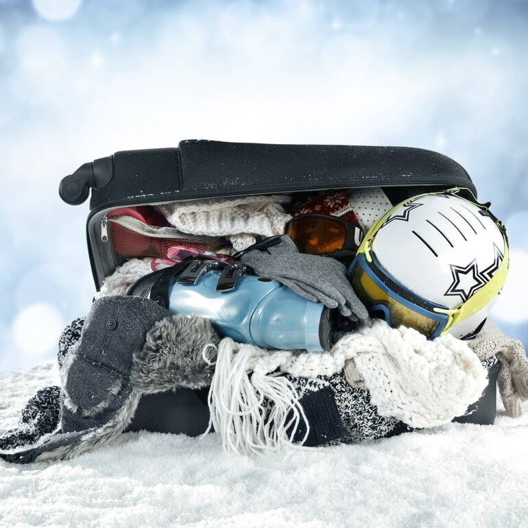 Offener, vollbepackter Koffer mit Winterkleider  | © Davos Klosters Mountains 