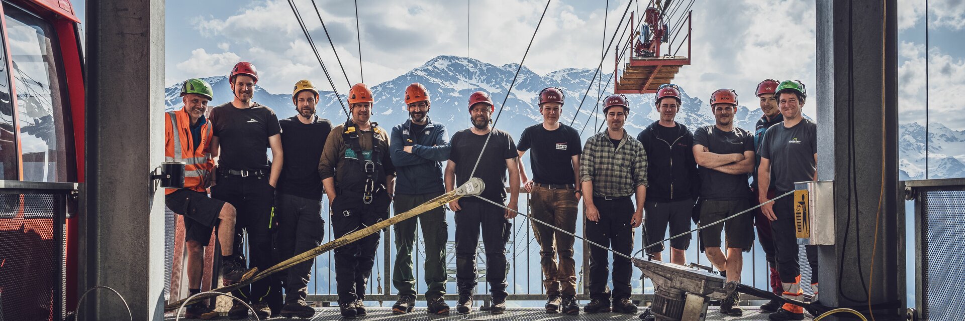 Gruppenbild Arbeiter Seilgzug Gotschnabahn | © Davos Klosters Mountains Arbeiter mit Helm stehen für ein Gruppenfoto in der Bergstation der Gotschnabahn zusammen. | © Davos Klosters Mountains