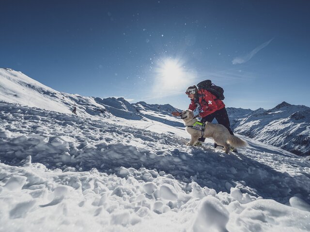 Lawinenhundeführerin Befehl Hund | © Davos Klosters Mountains Lawinenhundeführerin Seraina gibt Hündin Emma den Befehl zu suchen. | © Davos Klosters Mountains