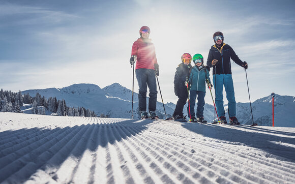 Eine Familie mit zwei Kindern steht mir Skiern auf einer perfekt präparierten Skipiste auf Madrisa. | © Davos Klosters Mountains
