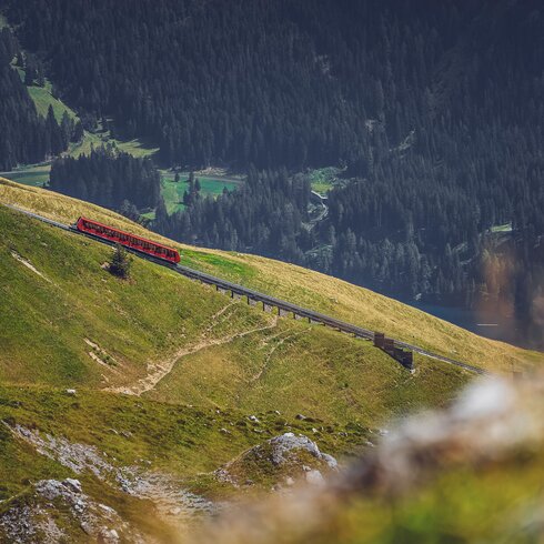 The red Parsenn funicular ascends the mountain, with the Davos valley behind it. | © Davos Klosters Mountains