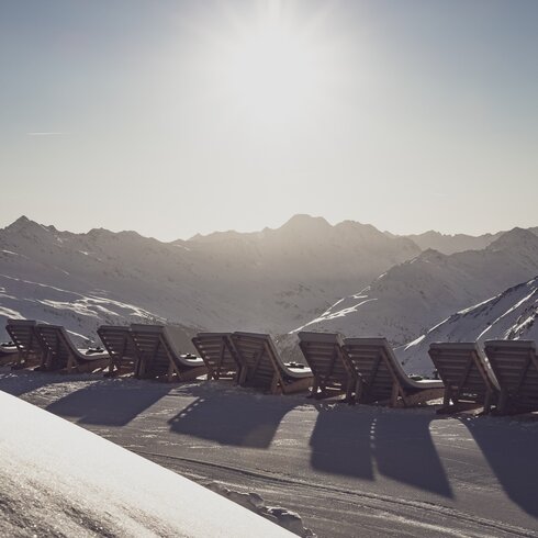 Liegestühle im Schnee mit Blick in die Berge. | © Davos Klosters Mountains