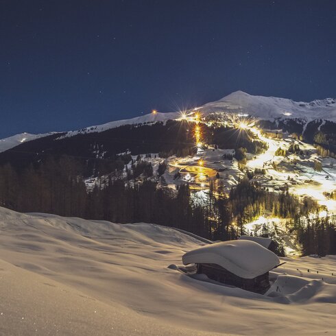 Illuminated slopes and sled run on the Rinerhorn by night. | © Davos Klosters Mountains
