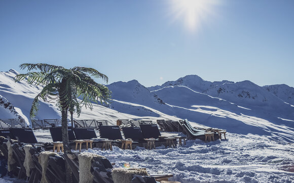 Unter Palmen auf der Sonnenterrasse entspannen, zu Sounds von internationalen DJs. | © Davos Klosters Mountains