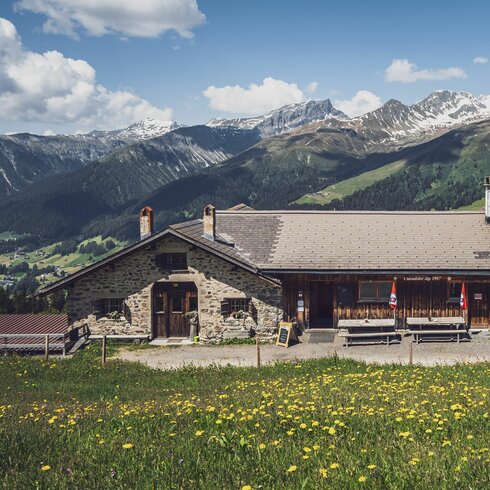 Blick auf die Schaukäserei mit den Bergen von Davos im Hintergund. | © Davos Klosters Mountains