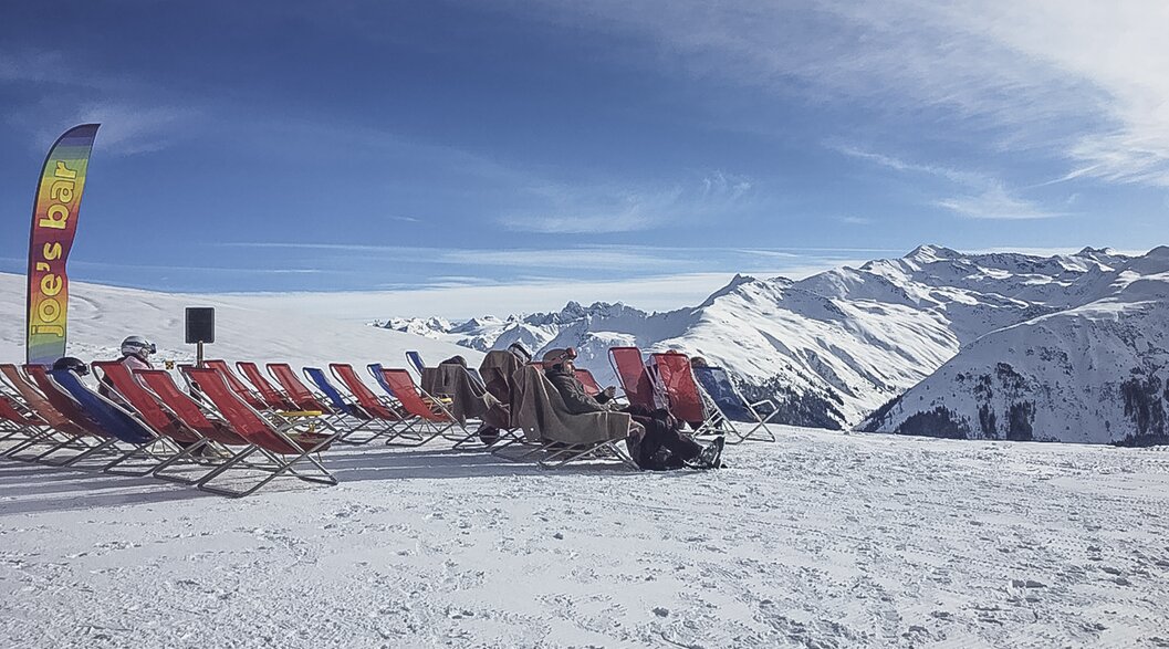Rote Liegen stehen aufgereiht auf der Aussichtsterrasse der Gruobenalp. | © Davos Klosters Mountains