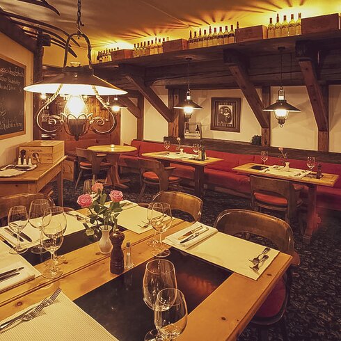 Gedeckte Tische stehen bereit im heimeligen Restaurant mit guter Küche. | © Davos Klosters Mountains