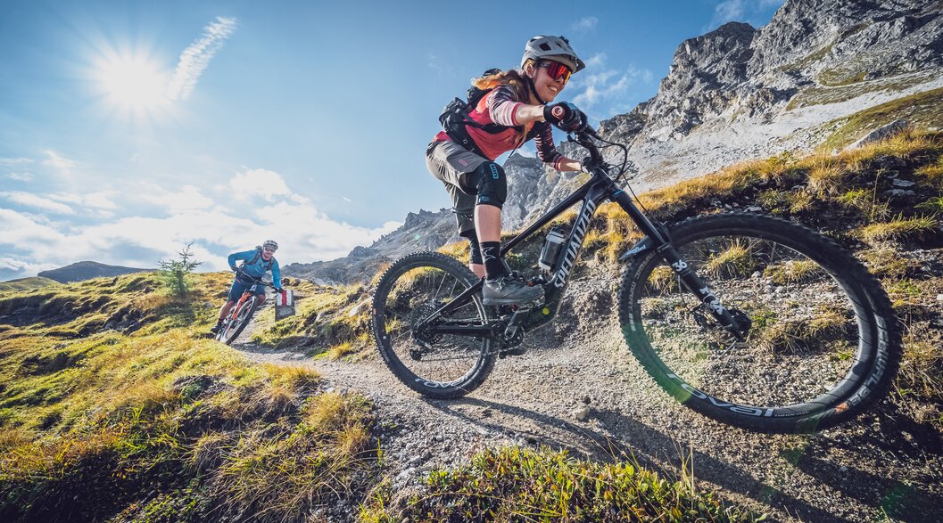 Eine Bikerin geniesst die rasante Abfahrt, ein Biker fährt hinterher. | © Davos Klosters Mountains