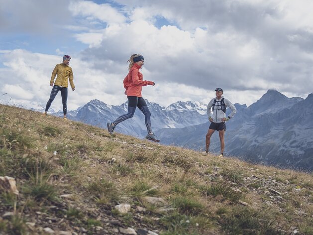 Trailrunning Training abwärts | © Davos Klosters Mountains Eine Läuferin wird von den beiden Trainern beobachtet, wie sie den Weg auf dem Jakobshorn hinab rennt. | © Davos Klosters Mountains