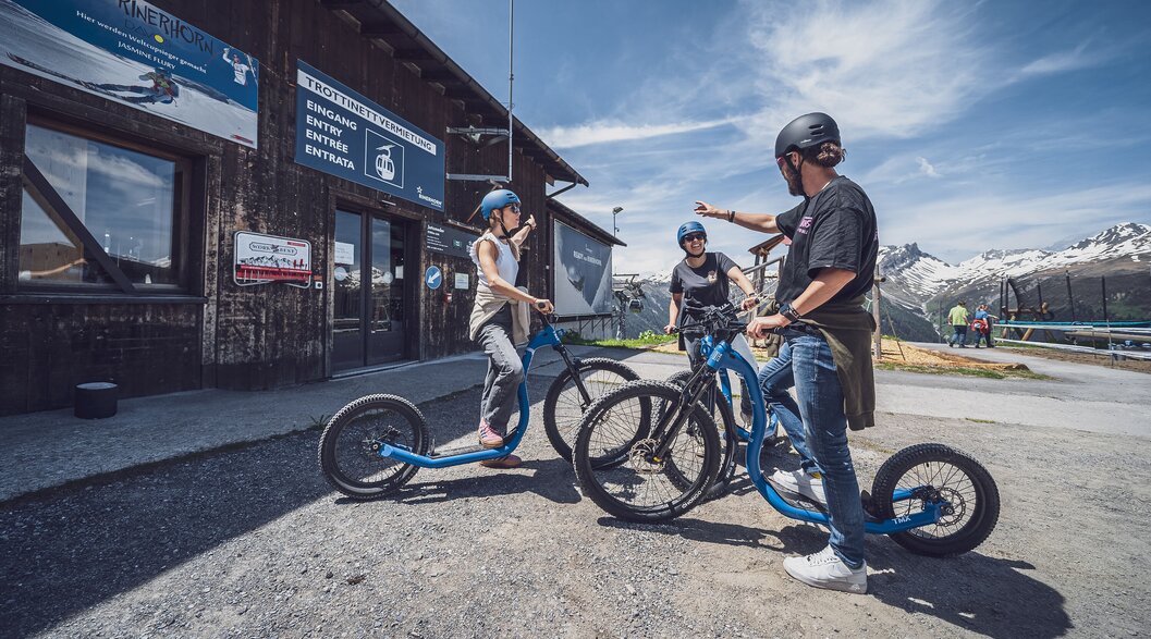 Drei Trottinettfahrer freuen sich auf die Abfahrt am Rinerhorn in Davos. | © Davos Klosters Mountains