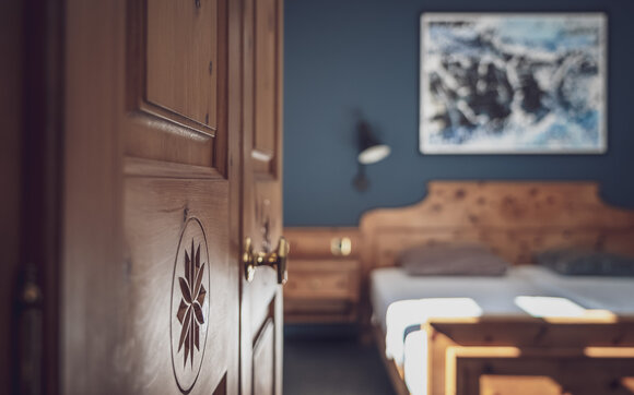 Zimmer mit Doppelbett, Bettwäsche und Nachttischlampe | © Davos Klosters Mountains 