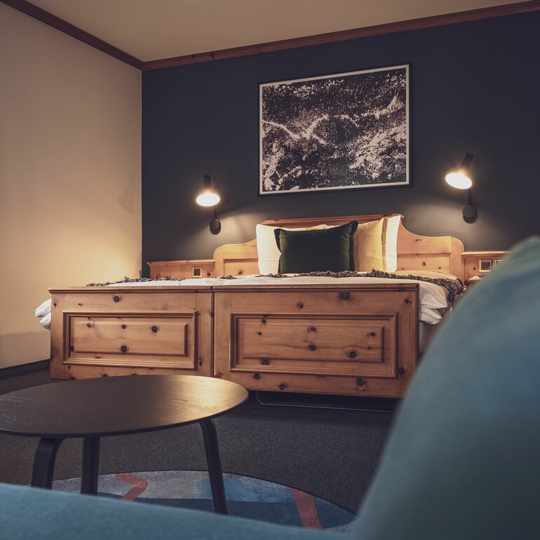Doppelbettzimmer mit Bettwäsche und Salontisch | © Davos Klosters Mountains 