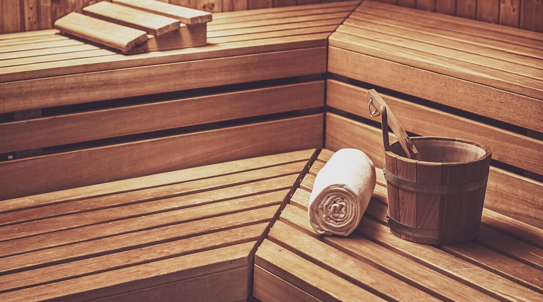 Finnish sauna made of wood with an infusion bucket, ladle and a sauna towel on the reclining area. | © Davos Klosters Mountains
